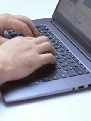 Close-up of hands typing on a laptop displaying data analysis charts, perfect for business contexts.